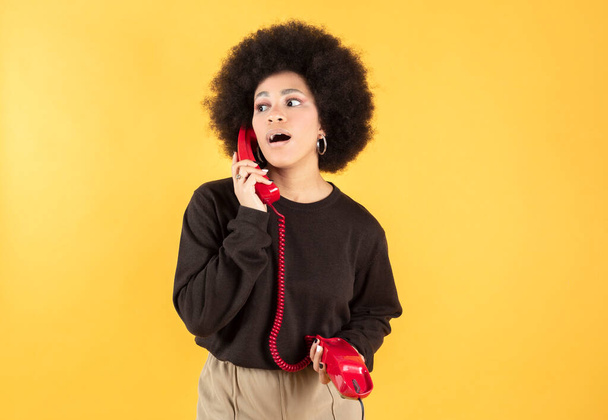 afro donna con un telefono tra le mani rosso - Foto, immagini