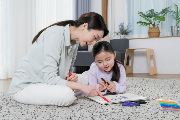 Asian mother and young daughter drawing together - Photo, image