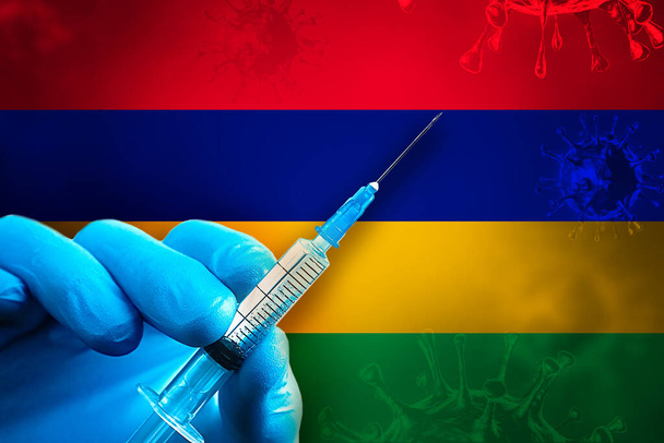 Mauritius Covid-19 Campagne de vaccination. Une main dans un gant de caoutchouc bleu tient une seringue avec le vaccin covid-19 contre le virus devant le drapeau mauricien. Concept de vaccination contre le coronavirus - Photo, image