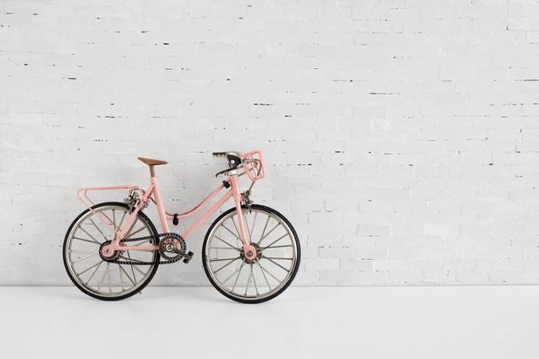 Концепция Всемирного дня велосипедов. Розовый велосипед на стене из белого кирпича. 3 июня. - Фото, изображение