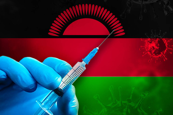 Malawi Covid-19 Рука в блакитній гумовій рукавичці тримає шприц з вакциною проти вірусу covid-19 перед прапором Малаві. Концепція вакцинації від коронавірусу - Фото, зображення
