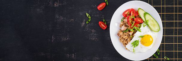 Νάσι Γκόρενγκ. Ινδονησιακό κοτόπουλο τηγανητό ρύζι σε σκούρο φόντο. Nasi Goreng είναι μια ινδονησιακή κουζίνα πιάτο με ρύζι, κρέας κοτόπουλου, κρεμμύδι, αυγό, λαχανικά. Πάνω όψη, πάνω, banner - Φωτογραφία, εικόνα