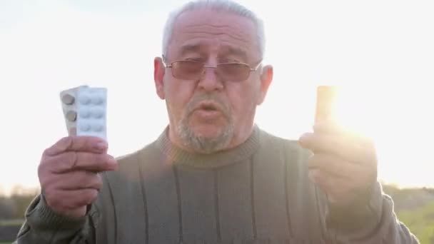 Portret van een volwassen man met pillen in zijn handen. - Video
