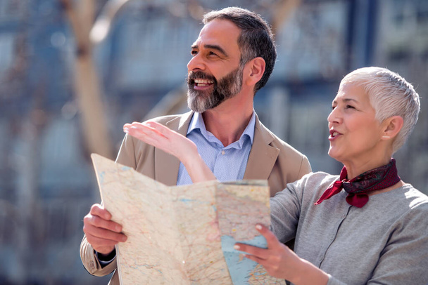 Retrato de pareja adulta en la ciudad, mirando el mapa. - Foto, imagen