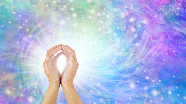 Healer channeling potężny Healing Energy - żeńskie dłonie miseczki tworząc kształt O z jasnym światłem między przeciwko żywy niebieski różowy wir potężny musujące energii i miejsca do kopiowania po prawej stronie - Zdjęcie, obraz