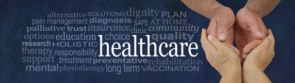 Health Care worker - female hands gently cradling male hands on a rustic dark blue stone background with a healthcare word cloud to the left - Photo, Image