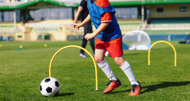 Child playing soccer ball on practice unit. School physical education class for kids. Football sports training camp. Exercise class for sporty boys - Foto, immagini