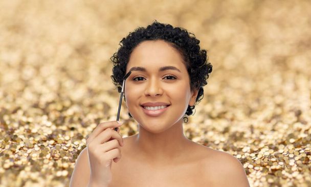 smiling african american woman with mascara brush - Photo, Image