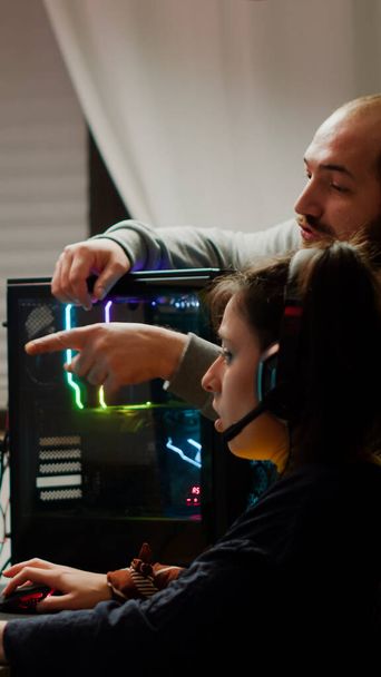 Man gamer teaching his girlfriend playing space shooter video game - Photo, Image