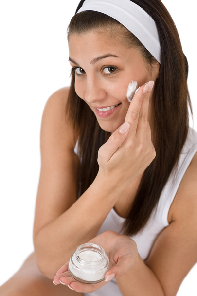 Beauty facial care - Young woman apply moisturizer on white background - Φωτογραφία, εικόνα