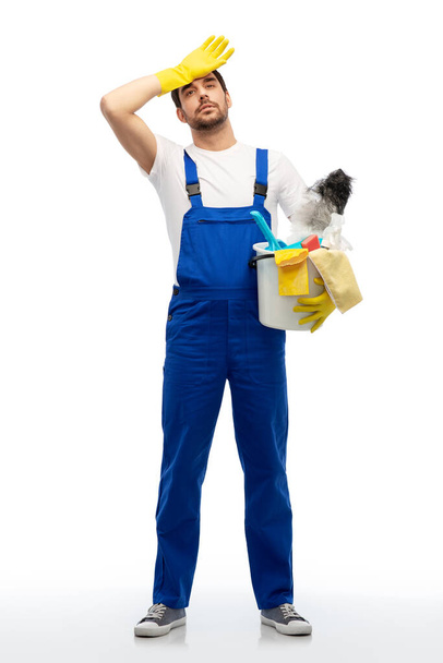 tired male cleaner with cleaning supplies - Fotoğraf, Görsel