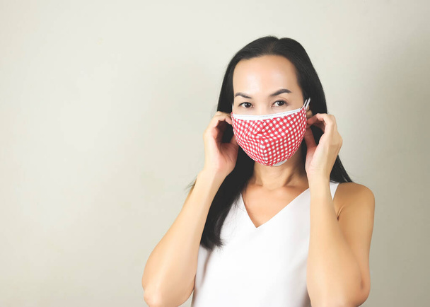 コロナウイルスや流行から保護するために二重または二つの顔マスクを身に着けているアジアの女性の肖像-安全性、医療、医療、衛生の概念. - 写真・画像