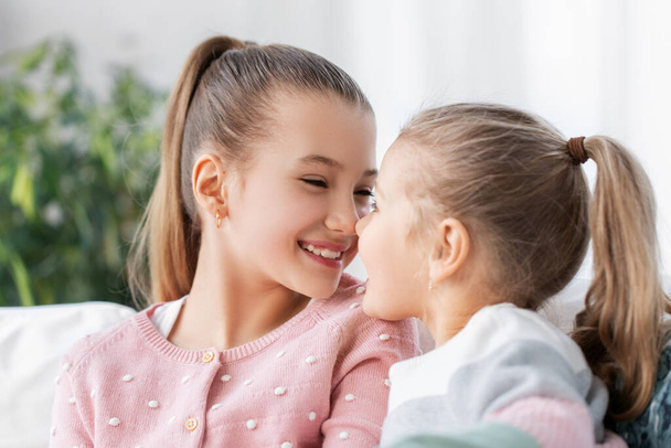 twee gelukkig glimlachende kleine meisjes of zussen thuis - Foto, afbeelding
