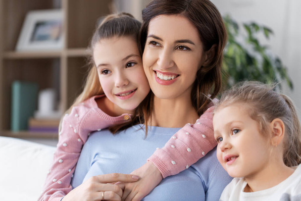 Χαρούμενη χαμογελαστή μητέρα με δύο κόρες στο σπίτι - Φωτογραφία, εικόνα