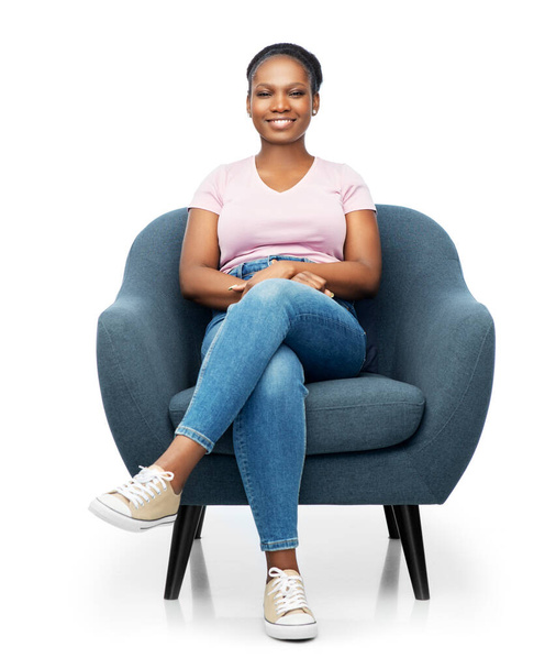 smiling african american woman sitting in armchair - Fotografie, Obrázek