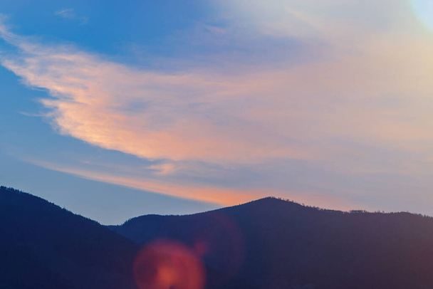 nuages cirrus au coucher du soleil sur les montagnes. Éclat ensoleillé et teinte. - Photo, image