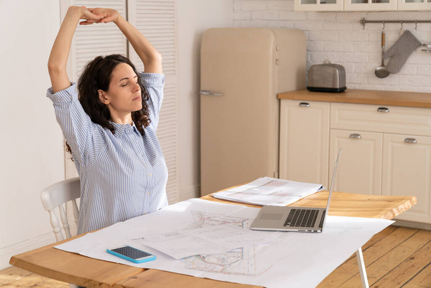 Businesswoman stretch to relieve tension from sedentary work in remote office at home in covid-19 - 写真・画像