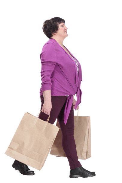 casual elderly woman with shopping bags striding forward. - Φωτογραφία, εικόνα