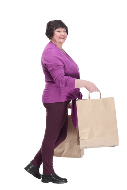 casual oudere vrouw met boodschappentassen stappen vooruit. - Foto, afbeelding