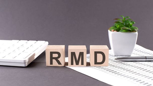 Концептуальне слово RMD на дерев'яних блоках на сірому фоні з зеленої квітки та діаграми
. - Фото, зображення