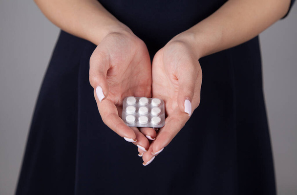 Mujer caucásica sosteniendo pastillas en la mano. - Foto, imagen