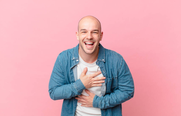 bald man laughing out loud at some hilarious joke, feeling happy and cheerful, having fun - Photo, Image