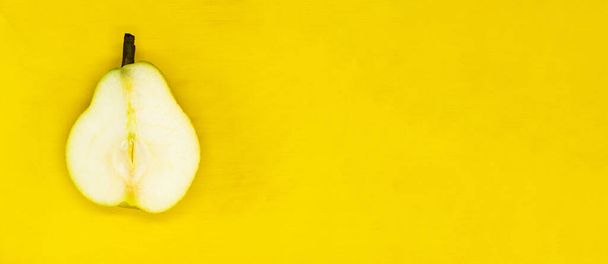 poire juteuse coupée isolée sur un fond jaune gros plan avec un espace vide pour votre texte - Photo, image