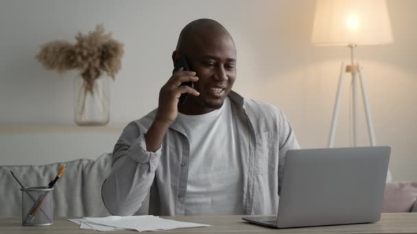 African American Man Talking On Phone Sitting At Laptop Indoors - Felvétel, videó