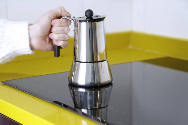 https://cdn.create.vista.com/api/media/small/468407170/stock-photo-woman-holding-modern-stainless-geyser-coffee-maker-kitchen-induction-panel