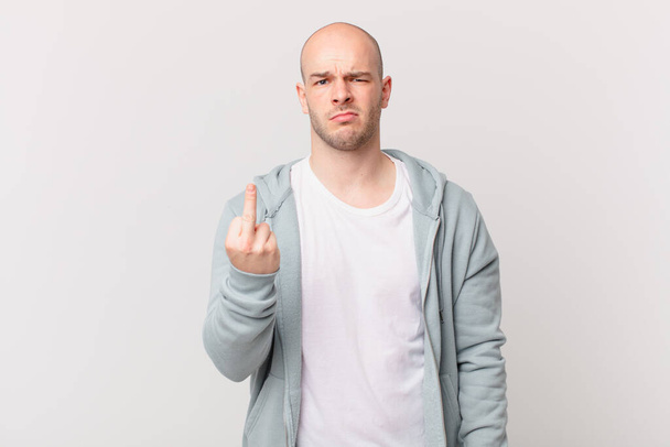 bald man feeling angry, annoyed, rebellious and aggressive, flipping the middle finger, fighting back - Valokuva, kuva