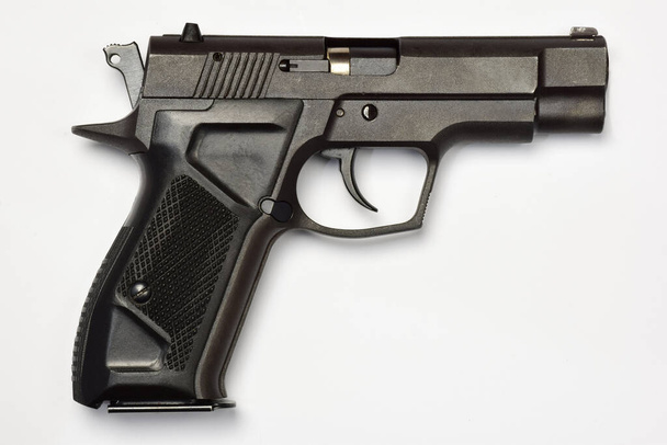 Pistolet de combat noir sur fond blanc. Vue latérale close up - Photo, image