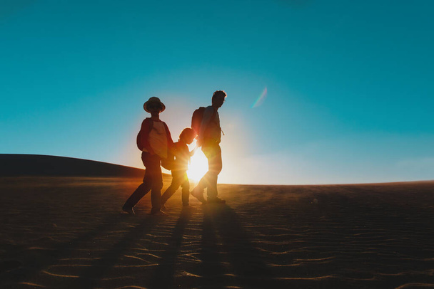 father with kids hiking at sunset, family travel in nature - Foto, afbeelding