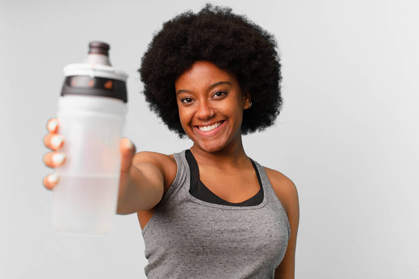 black afro fitness woman with a towel and water can - Foto, Imagem