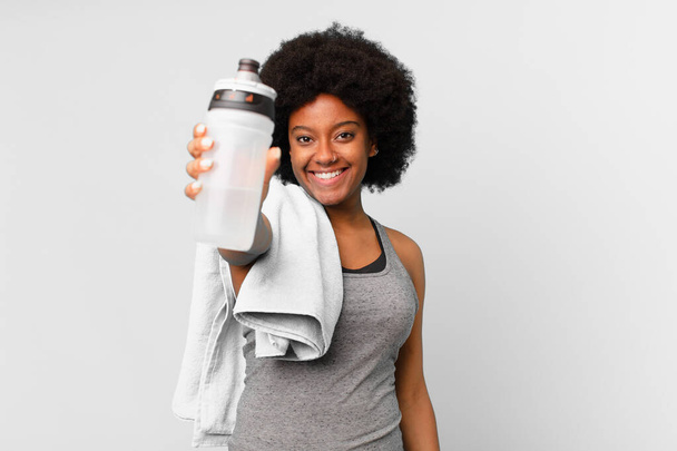 black afro fitness woman with a towel and water can - Foto, Imagem