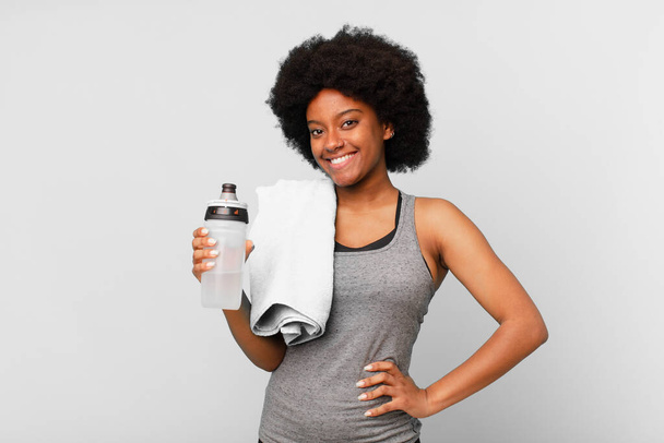 czarny afro fitness kobieta z ręcznikiem i woda może - Zdjęcie, obraz