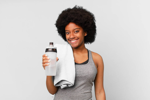 black afro fitness woman with a towel and water can - Фото, изображение