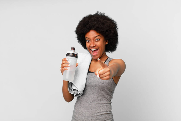 black afro fitness woman with a towel and water can - Zdjęcie, obraz