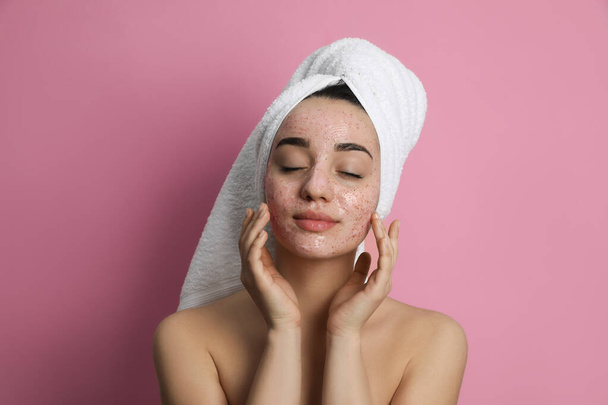 Woman applying pomegranate face mask on pink background - Foto, immagini