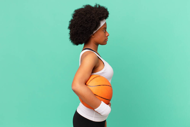afro woman on profile view looking to copy space ahead, thinking, imagining or daydreaming. basketball concept - Fotoğraf, Görsel