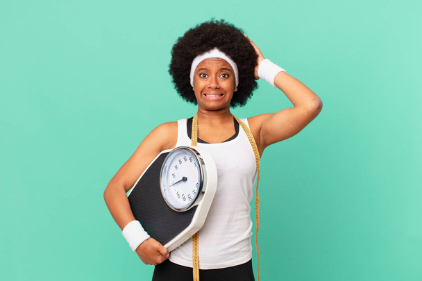 Afro-Frau fühlt sich gestresst, besorgt, ängstlich oder verängstigt, mit den Händen auf dem Kopf, in Panik vor einem Diätkonzept - Foto, Bild