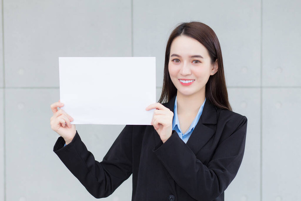 Mujer trabajadora de negocios asiática sostiene papel blanco para presentar algo. - Foto, imagen