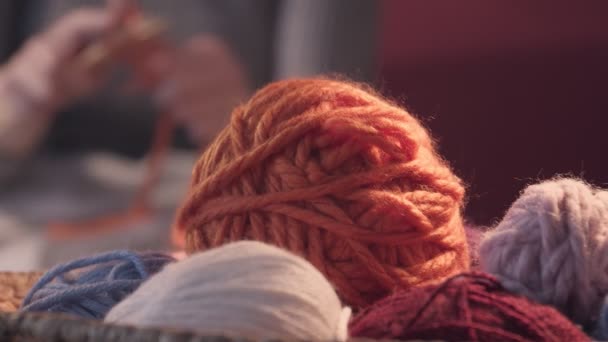 Giovane donna che lavora a maglia a casa la sera, concentrarsi sui fili - Filmati, video