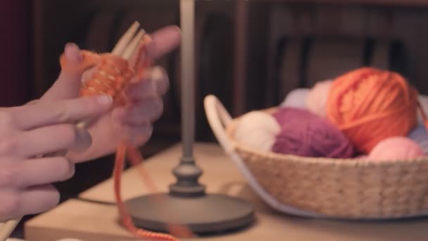 Giovane donna che lavora a maglia a casa la sera, primo piano - Filmati, video