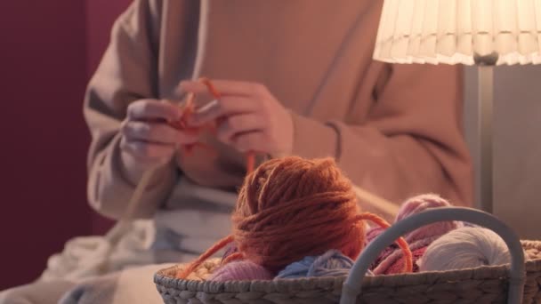 Giovane donna che lavora a maglia a casa la sera, primo piano - Filmati, video