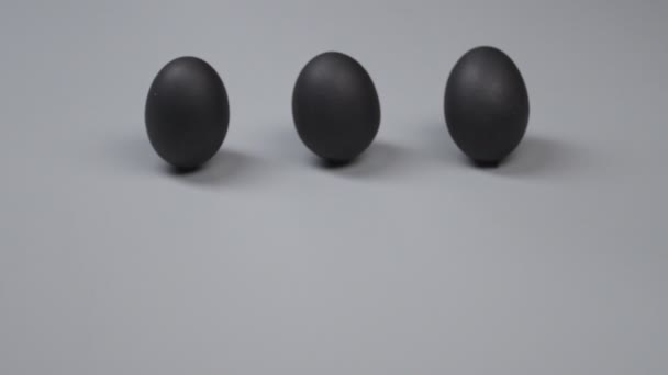 Huevos enteros y uno roto sobre fondo gris. Concepto de singularidad - Metraje, vídeo
