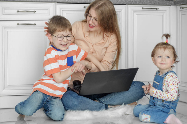 Kleine kinderen maken het moeilijk voor mama om thuis te werken. Werk online. Kinderen spelen in de buurt mama. - Foto, afbeelding