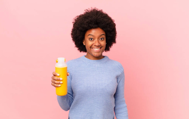 afro woman looking happy and pleasantly surprised, excited with a fascinated and shocked expression. smoothy concept - Фото, изображение