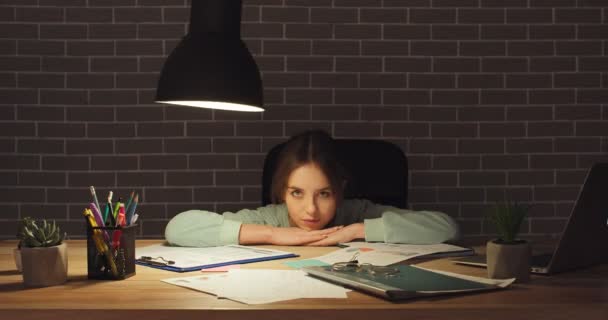 Jonge vrouwelijke freelancer aan tafel laat in de avond - Video