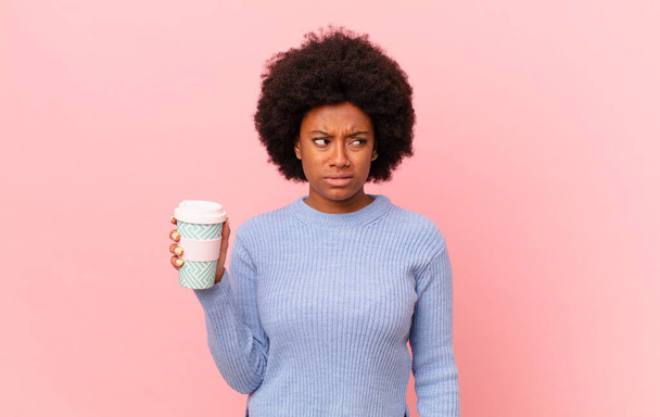 afro woman feeling sad, upset or angry and looking to the side with a negative attitude, frowning in disagreement. coffee concept - Φωτογραφία, εικόνα