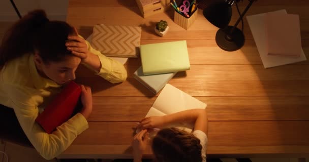 Cansada mulher ajudando sua filhinha com lição de casa tarde da noite - Filmagem, Vídeo